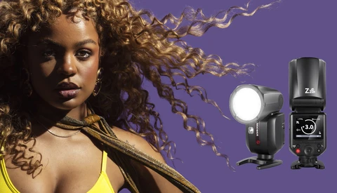 Portrait of woman with curled hair against purple background, with two external camera flashes displayed on right side.