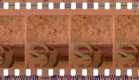 Film strip with expired color film showing degraded images of architectural interior with curved elements.