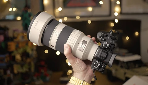 Mirrorless camera with large telephoto lens held up to display the setup during holiday season.