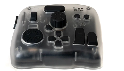 Transparent game controller with black buttons and analog sticks, displayed against white background.