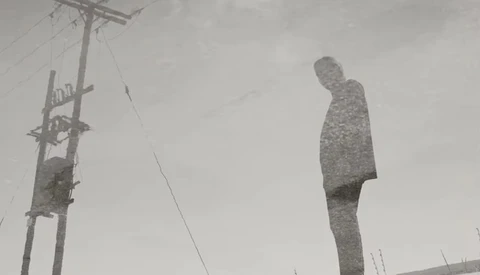 A tall, textured human figure stands against a utility pole in an overcast landscape.