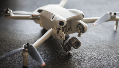 DJI Mavic 3 drone positioned on gray textured surface with propellers extended.