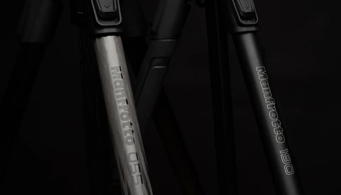 Two bicycle fork shock absorbers with text engravings on metallic stems against a dark background.