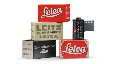 Stacked vintage Leica film camera boxes and film canisters arranged in a pyramid composition.