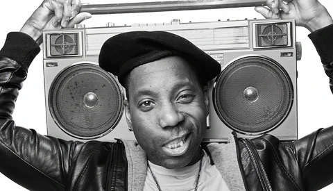 Person holding a large boombox above their head while smiling at the camera.
