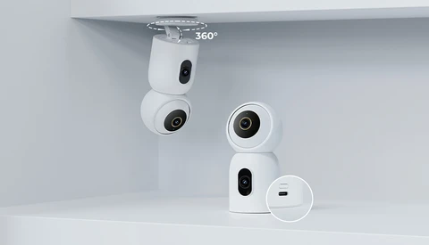 Product shot of white compact surveillance cameras mounted on white shelving, showing 360-degree rotation capability.