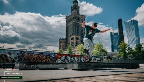 Skateboarder performing a trick on a concrete rail with Chicago skyline in background.