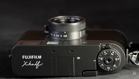 Fujifilm Xhalf rangefinder camera with mounted lens, shot from above against dark background.