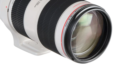 White telephoto lens with black focus ring and red text markings on barrel against white background.