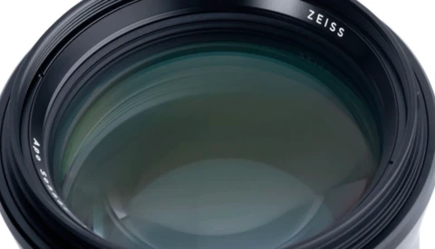 Close-up of a Zeiss camera lens showing multi-coated glass elements and internal optical construction.
