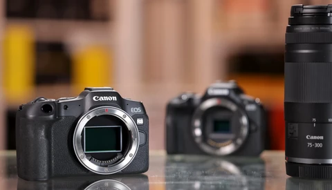 Canon EOS R5 mirrorless camera body with Canon 75-300mm telephoto lens displayed on reflective surface.