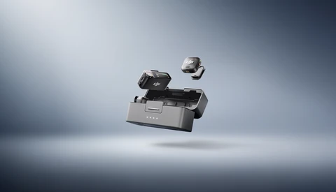 Professional camera equipment and accessories suspended in mid-air against a gradient gray studio backdrop.