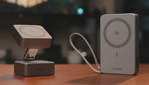 Three smartphone magnetic charging accessories arranged on a wooden surface with blurred interior background.