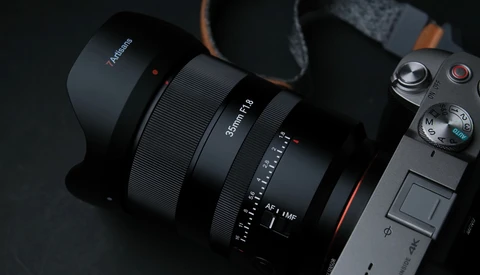 Sony mirrorless camera with wide-angle lens and lens hood attached, displayed on dark surface.