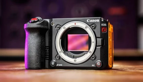 Canon EOS R5 mirrorless camera body displayed against colorful purple and orange gradient lighting.