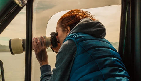 Person photographing through a car window with a telephoto lens.