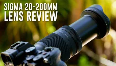 Sigma 20-200mm lens mounted on a DSLR camera body against a blurred green background.