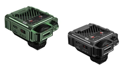 Two compact flash units displayed side by side: one in sage green and one in black, each with top-mounted reflectors and front-facing control panels.