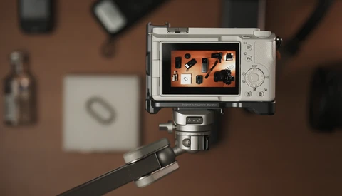 Compact camera mounted on a tripod displaying an overhead flat lay composition on its rear screen.
