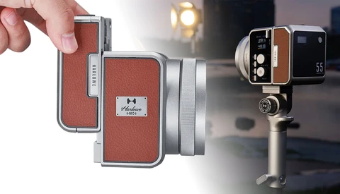 Vintage compact camera with red leather exterior and silver metal trim, held in hand against blurred background.