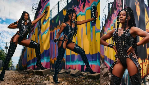 Three dancers in black sequined outfits posing dynamically in front of a colorful striped mural.