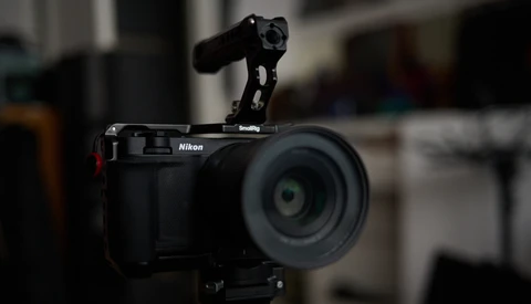 Nikon mirrorless camera with SmallRig rig mounted on top, featuring a microphone attachment and wireless receiver.