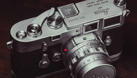 Vintage rangefinder camera with chrome top plate and black body, fitted with a manual focus lens.