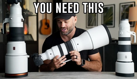 Man holding and comparing two white telephoto lenses with black accent bands at a table.
