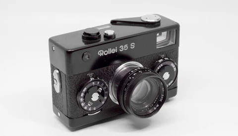 Rollei 35 S compact film camera with black body and textured grip, showing dual manual control dials and fixed lens.