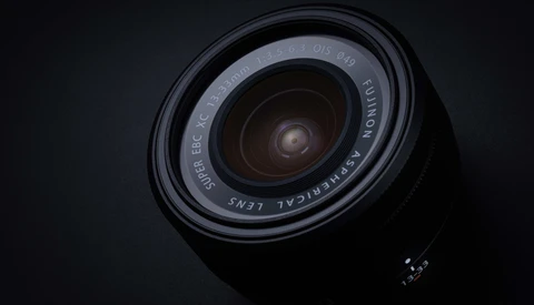 Wide-angle lens photographed from above against a dark background, showing the front glass element and barrel markings.