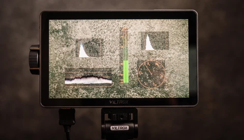 Viltrox monitor displaying waveform and focus peaking tools with live video feed on textured surface.