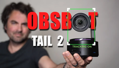 Man holding a compact camera tracking device with green crosshairs overlay and red text reading "OBSBOT TAIL 2".