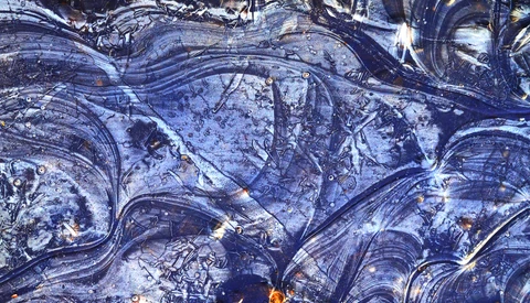 Aerial view of winding roads and water features with blue and gold tones.