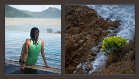 Woman in green swimsuit sitting on dock facing calm lake with mountains in background.