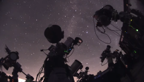 Film and television camera equipment silhouetted against a starry night sky.