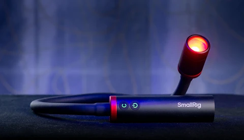 SmallRig handheld light with illuminated red-orange head mounted on adjustable arm.