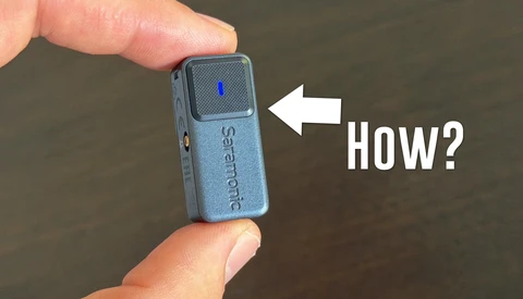 Close-up of a small blue portable audio device held between two fingers, with a white arrow pointing to the top surface and text reading 'How?'.