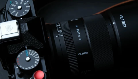 Viltrox lens mounted on camera with exposure dials visible in overhead composition.