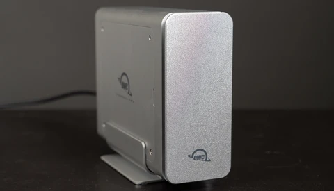 Two external hard drives with silver aluminum enclosures positioned side by side on a dark surface.