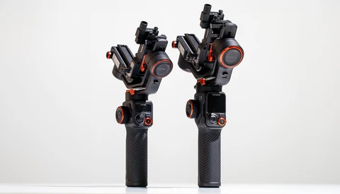 Two black gimbal stabilizers with orange accents and articulated arms displayed side by side against a white background.