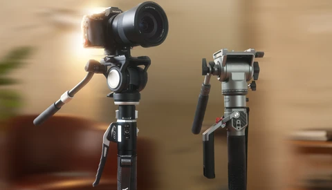Two gimbal stabilizers mounted on tripods against a blurred indoor background.