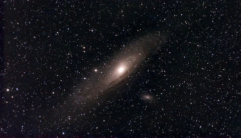 Spiral galaxy with bright central core surrounded by dust lanes and stars against dark space.