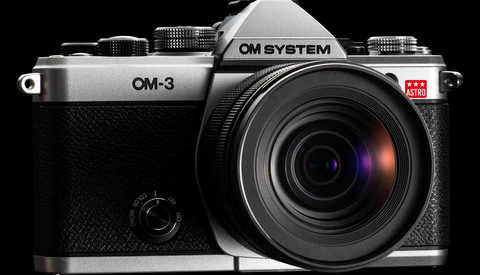 OM System OM-3 mirrorless camera with attached lens, photographed against black background.