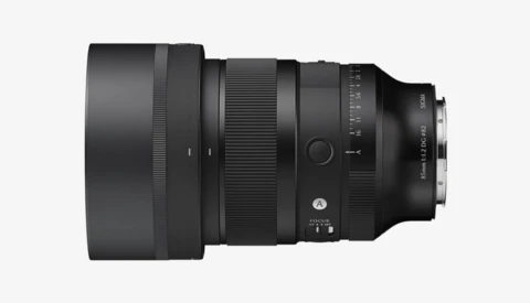 Black telephoto lens with extended barrel and focus ring, shown in profile against neutral background.