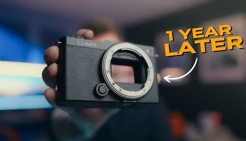 Panasonic Lumix mirrorless camera body held in hand, shown from front with lens mount exposed.