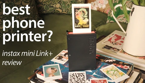 Instax Mini Link+ printer surrounded by instant photo prints on a patterned surface with floral decorations.