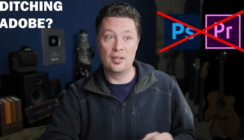 Man in dark hoodie speaking to camera with Adobe Creative Suite logos crossed out behind him.
