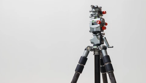 Professional video camera rig mounted on tripod with follow focus system and wireless monitor.