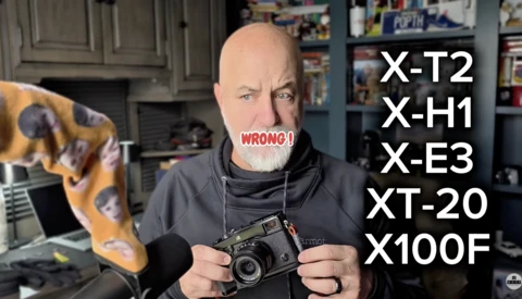 Photographer holding a vintage rangefinder camera with a list of camera models overlaid, marked "WRONG."