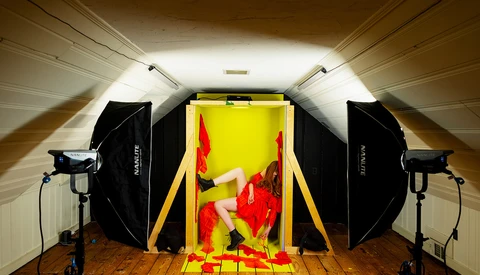 Professional studio setup with softboxes and key light illuminating red peppers on yellow background.